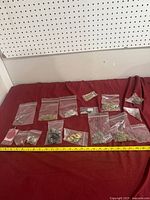 Overview of lot showing multiple resealable bags of costume jewelry on red cloth