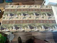 Full view of woven rug laid flat showing overall pattern and size relative to surrounding objects