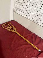 Full view of cane carpet beater on red surface