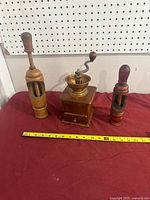 Overall view of three grinders with measuring tape for scale