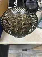 Top view of the brass bowl showing detailed floral engravings and patterns inside.