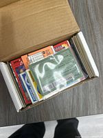 Box containing a variety of vintage sports trading cards from the 1970s-1980s era, cards visible stacked inside the box.