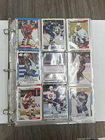 Photo showing one 9-pocket sheet with 9 vintage hockey cards including Mike McPhee and players from the Calgary Flames and Winnipeg Jets.