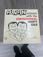 Front of vinyl record cardboard sleeve showing title, cartoon illustration of two men, and brand label 'Cals-Cale Records'.