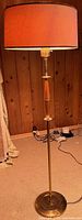 Full view of metal and wood floor lamp with drum shade