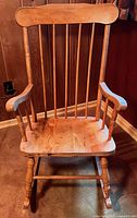 Front view of wooden rocking chair showing spindle back, seat, legs, and rockers