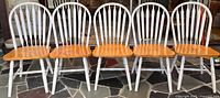 Front view of five matching two-tone wooden chairs