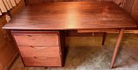 Full view of desk front showing drawer bank and tapered legs