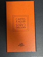 Orange Hermes branded box with Cartes à Nouer text on top, used for packaging knotting cards