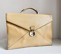 Front view of beige textured leather LANCEL Paris briefcase with flap and silver-tone turn-lock