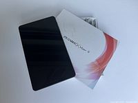 ZTE Grand X View 4 tablet placed on its box, showing front screen off, with charger cables packed inside box.