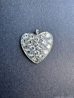 Front view of heart-shaped pendant showing pavé-set diamonds