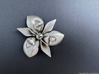 Front view of the large vintage sterling silver flower brooch showing detailed textured petals and central bead.