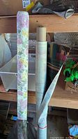 Two patterned fabric/vinyl rolls on shelf