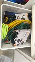 Drawer with green, yellow, and black packaged HDX cords visible