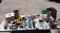 Overall view of table with assorted ropes, cords, hardware, storage bins