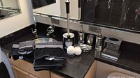 Full countertop view showing towels, toilet brush set, and mirrored accessories