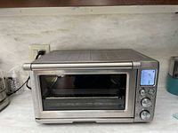 Front view showing stainless steel Breville Smart Oven Pro, glass door, LCD display, control knobs