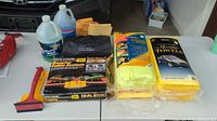 All items grouped on table showing booster cable box, fluids, towel packs and ice scraper