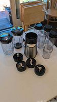 Full set showing motor base, blender jar, four cups, three blade lids