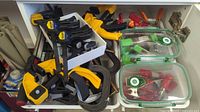 Drawer containing multiple yellow and black trigger clamps, black quick-grip clamps, steel C-clamps and assorted spring clamps