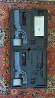 Two DJI Osmo Mobile 2 gimbals in molded foam cases with cables and paperwork visible