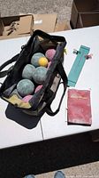 Open bag showing bocce balls, pallino, scorekeeper board, booklet