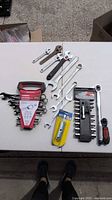 All items laid out: sealed Husky wrench set, loose combo wrenches, adjustable wrenches, socket rail with ratchet, packaged spark plug wrench