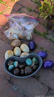 All stones grouped: bagged cream eggs, loose eggs, purple eggs, grey bowl with round stones
