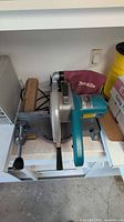Top view of Makita chop saw showing blade housing, handle, vice clamp