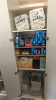 Full cabinet view showing napkins, detergents, Ziploc boxes, tissues, foil and trays