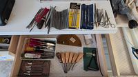 Top shelf overview of needle files, forceps, packaged tools