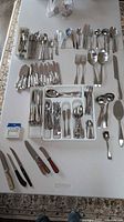 Full spread of flatware set laid out on table showing overall quantity and variety