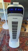 Full view Pelonis tower fan standing on base with power cord visible