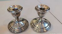 Front view of both Pilgrim sterling candle holders