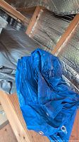 Folded blue tarp showing metal grommets and texture