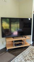 Front view showing Vizio 70-inch TV on stand with Blu-Ray player and remote