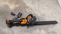 Full view of hedge trimmer with battery, charger, blade cover