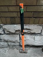 Full view of sledge hammer leaning against wall