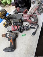 Group shot showing six power tools on table including Milwaukee reciprocating saw, grinders, DeWalt and Worx tools