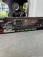 Front view of boxed Die-Cast Promotions 1:64 scale Schneiders tractor trailer