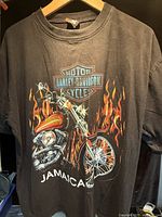 Front view of black Harley Davidson Jamaica graphic T-shirt on hanger