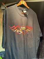 Front view of black Harley-Davidson flame graphic T-shirt on hanger