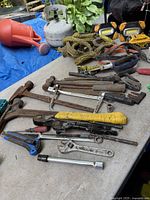Wide view of assorted hand tools, hardware, propane tank, rope and work lights