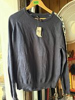 Full view of navy Michael Kors crewneck sweater hanging