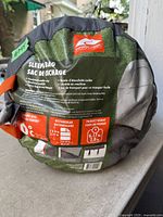 Front label on stuffed sleeping bag showing brand, specs and temperature rating