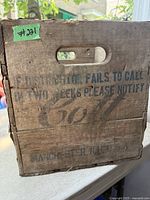 Side of crate with notification message and Cott logo