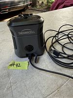 Thermacell mosquito repellent device with attached USB cable on tabletop