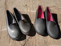 Two pairs of Cougar slip-on shoes on wooden surface