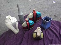 all six vases displayed on purple cloth